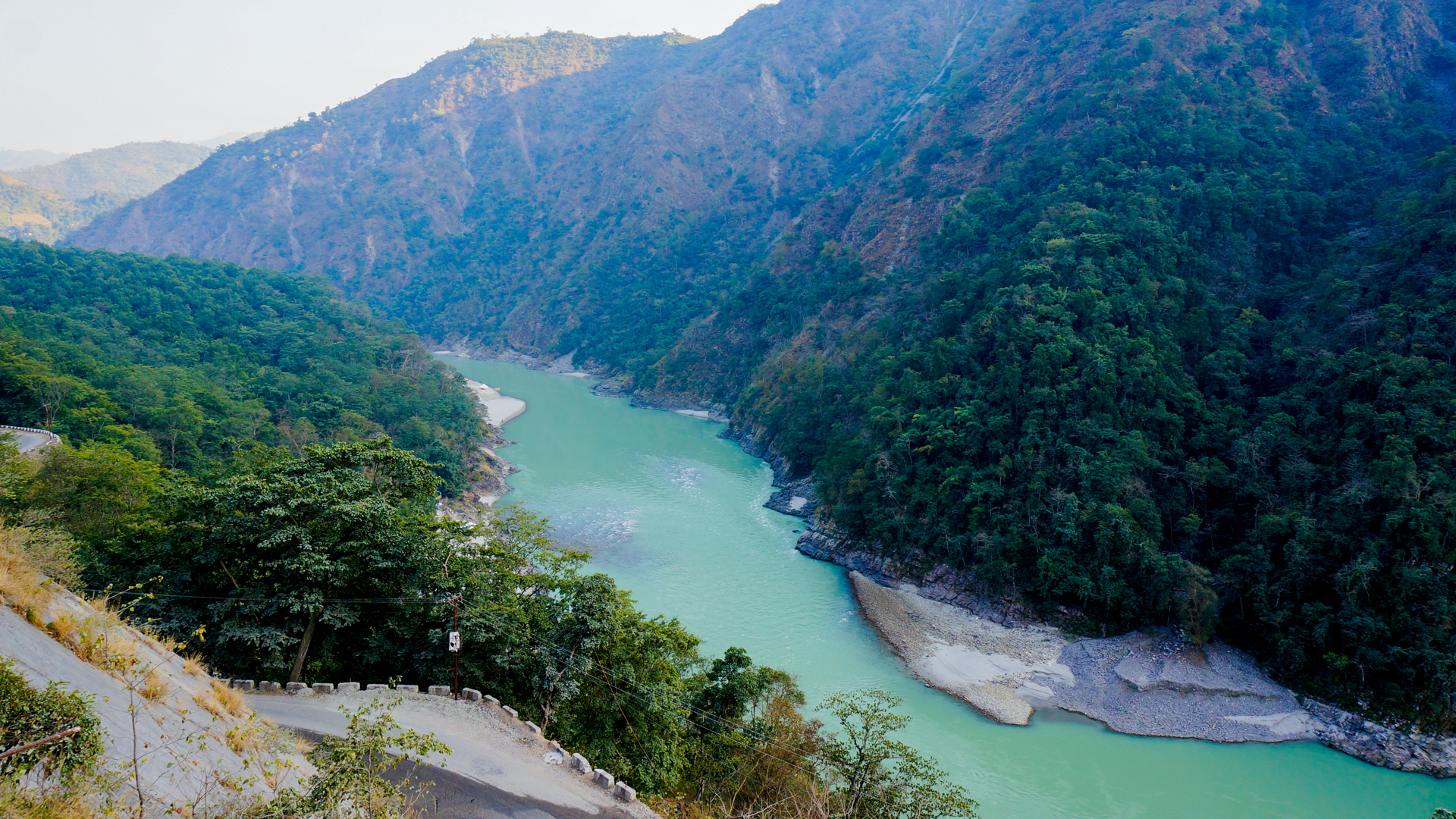 Jade-green river winding through a deep forested gorge